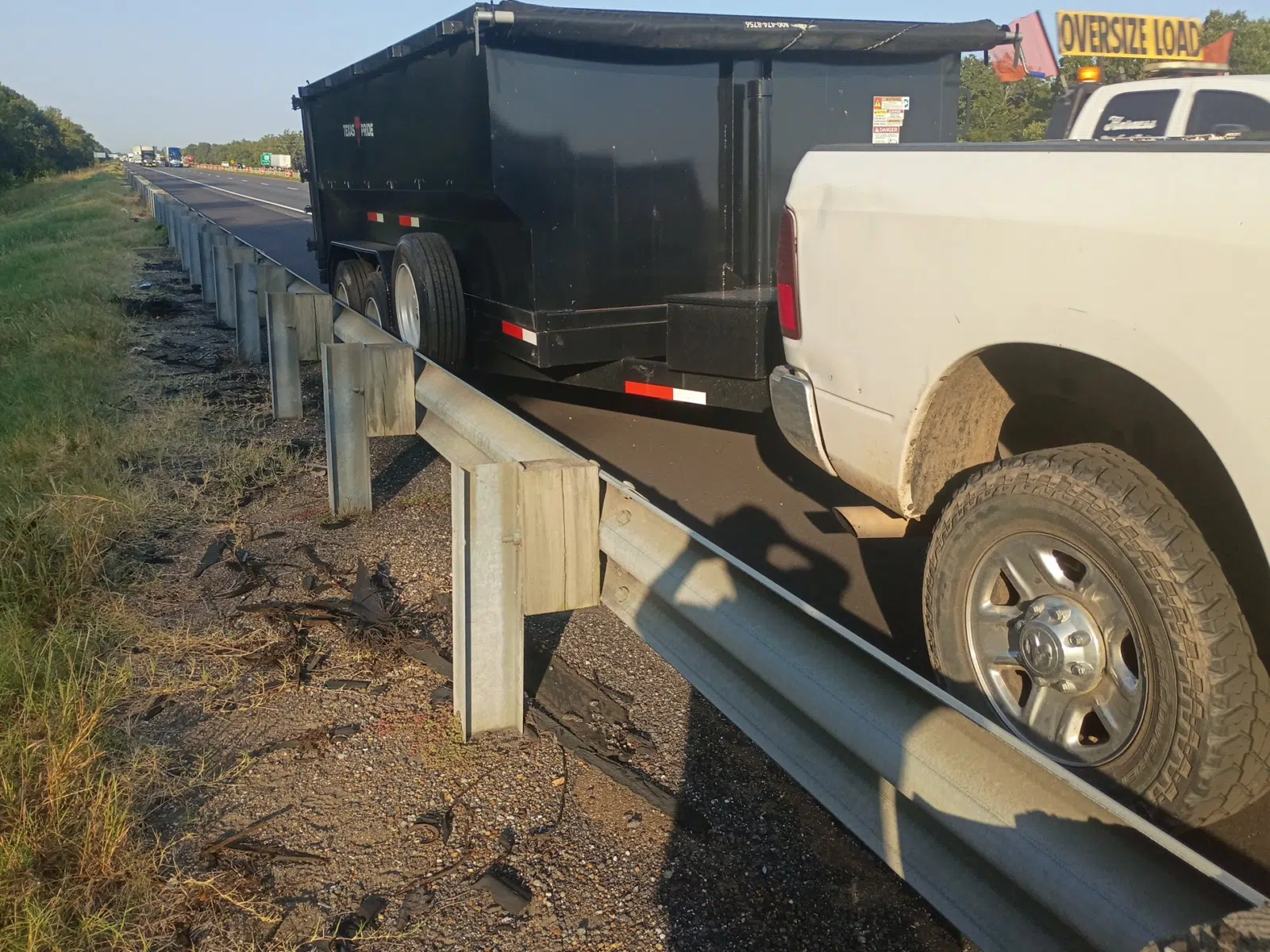 Dump trailer and service pickup stopped beside a highway guardrail — Rickey Alexander Mobile Truck & Trailer Repair in Forrest City