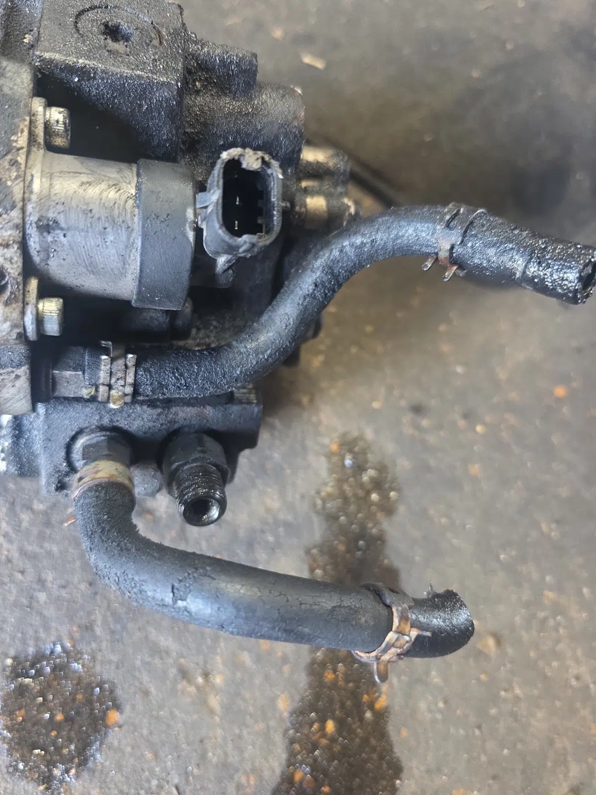Removed hydraulic pump with cracked hoses on a shop floor — Rickey Alexander Mobile Truck & Trailer Repair in Forrest City